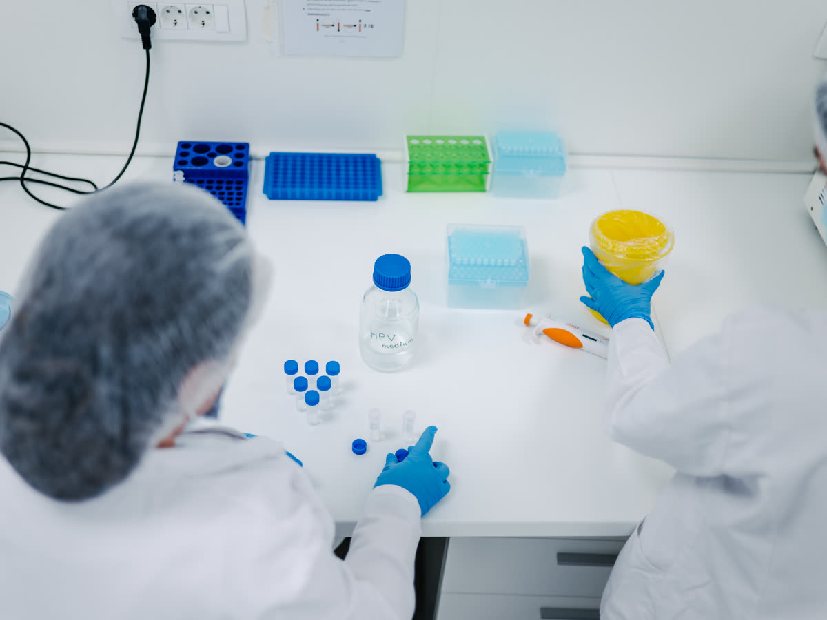 Two laboratory technicians working at a bench in the Ginekaliks laboratory